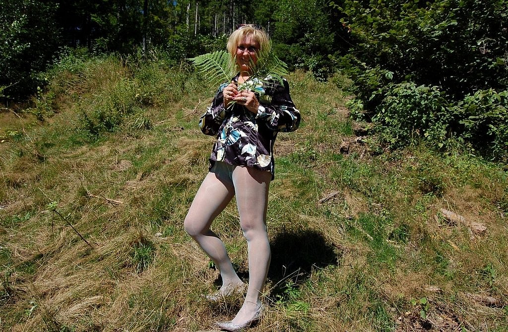 Horny housewife in light green pantyhose posing in the forest