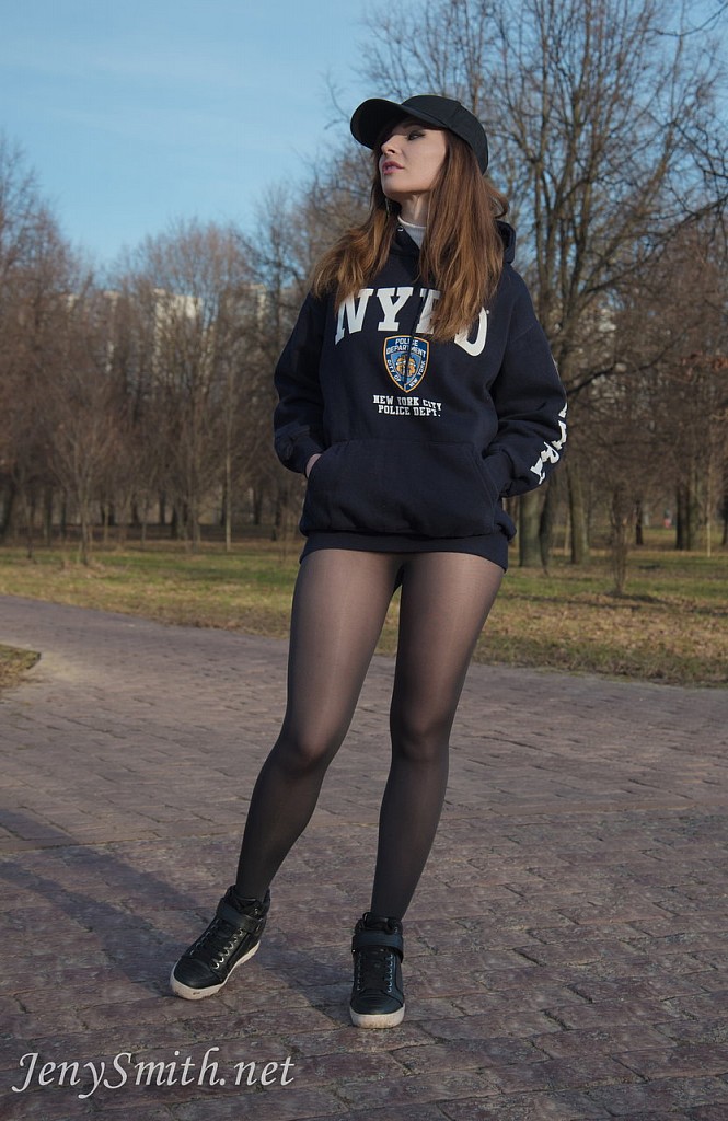 Jeny Smith in NYPD hoodies shows her legs in black seamless pantyhose outdoors